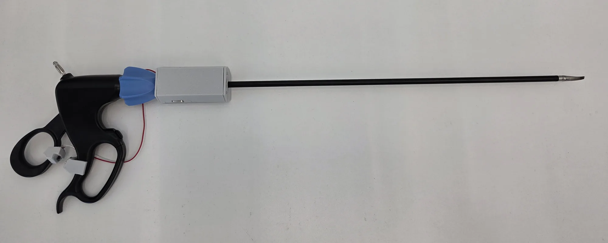 A standard laparoscopic grasper with the in-vivo logger on its shaft near the handle